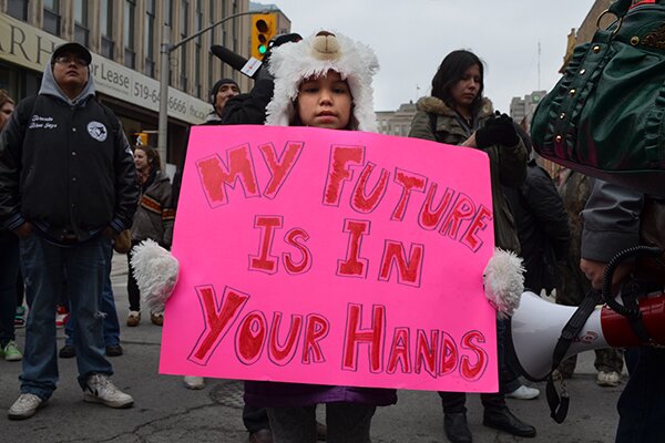 A young girl holds a placard at an Idle No More protest in London, Ont. on March 21, 2013. (Creative Commons licence provided courtesy of Flickr user The Indignants)
